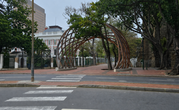 The entrance to Company's Garden in Cape Town, South Africa, featuring the iconic wooden archway, mature trees, historic buildings, and a peaceful city park setting in the heart of the CBD.