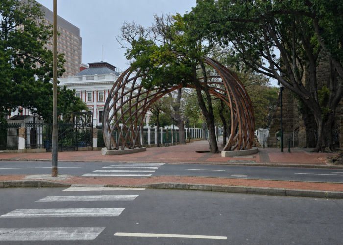 The entrance to Company's Garden in Cape Town, South Africa, featuring the iconic wooden archway, mature trees, historic buildings, and a peaceful city park setting in the heart of the CBD.