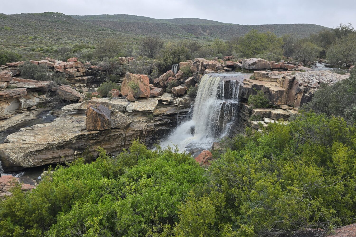 Waterfall flowing near Nieuwoudtville in the Northern Cape, surrounded by rugged rocks and seasonal wildflowers on the 4-Day Wildflower Tour